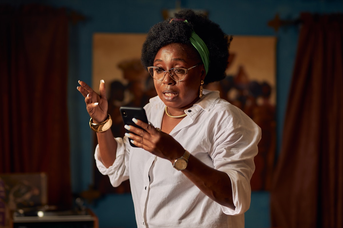 woman staring at phone shocked